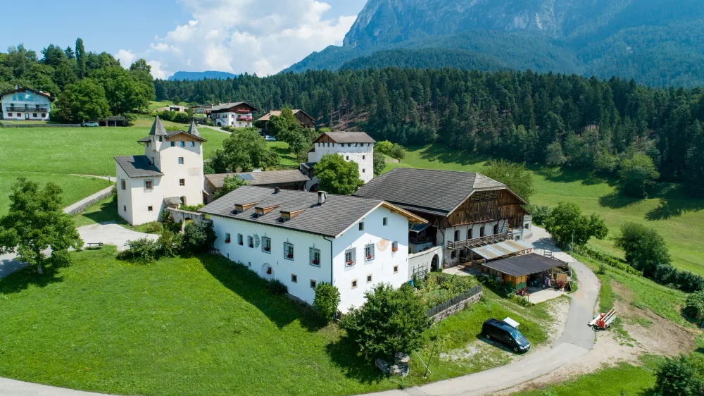 Vogelperspektive des malerischen Edelansitzes mit Hofschank, umgeben von idyllischer Natur. Ideal für Ferienwohnungen und einen entspannten Urlaub auf dem Bauernhof.